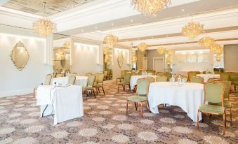 a large , elegant dining room with numerous tables and chairs arranged for a formal event at Thornton Hall Hotel & Spa