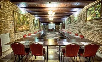 a room with brick walls and wooden beams has several tables set up for meetings at Gaja