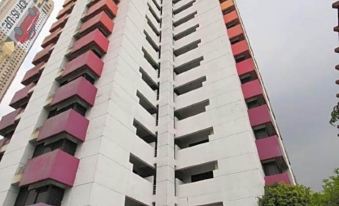 The two-bedroom apartment is located in a tall white building with red and gray balconies at Baiyoke Suite Hotel