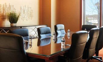 a conference room with a wooden table , black leather chairs , and two clear glasses on the table at Mount Airy Casino Resort - Adults Only