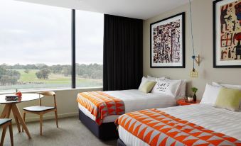 a hotel room with two beds , one on the left side and the other on the right side of the room at The Larwill Studio Melbourne - Art Series