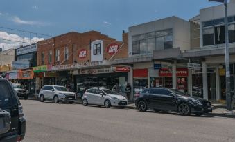 a busy city street with numerous cars parked along the side of the road , creating a bustling atmosphere at Hamilton on Beaumont
