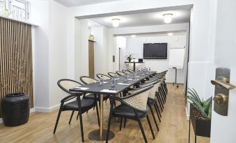 a long dining table with chairs arranged around it , ready for a group of people to sit and eat at Hotel Sct. Thomas