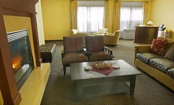 a hotel room with two chairs , a coffee table , and a television in the corner at The Landing Hotel