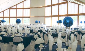 a large banquet hall is set up for a formal event , with tables covered in white tablecloths and chairs arranged around them at Devil's Head Resort