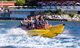 a group of people riding a banana boat in the water , enjoying their time together at Monte-Carlo Bay Hotel & Resort