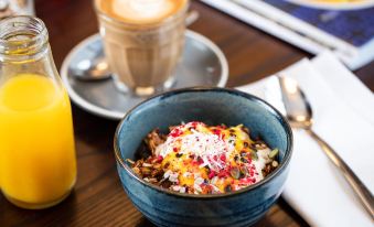 a bowl of food with a colorful topping and a cup of coffee on a table at Rydges Wellington Airport, an EVT hotel