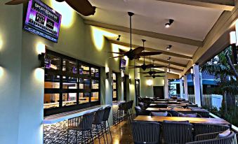 a modern bar with a ceiling fan , bar stools , and a television mounted on the wall at Riverside Hotel