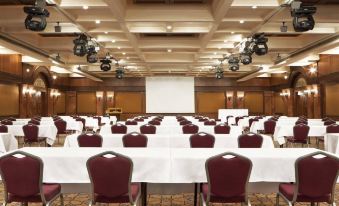 a large conference room with rows of chairs arranged in a semicircle , ready for a meeting at Sheraton Hotel