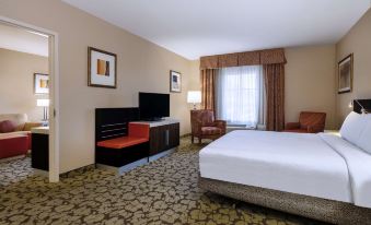 a hotel room with a king - sized bed , a flat - screen tv , and a desk with a laptop at Hilton Garden Inn Las Vegas Strip South