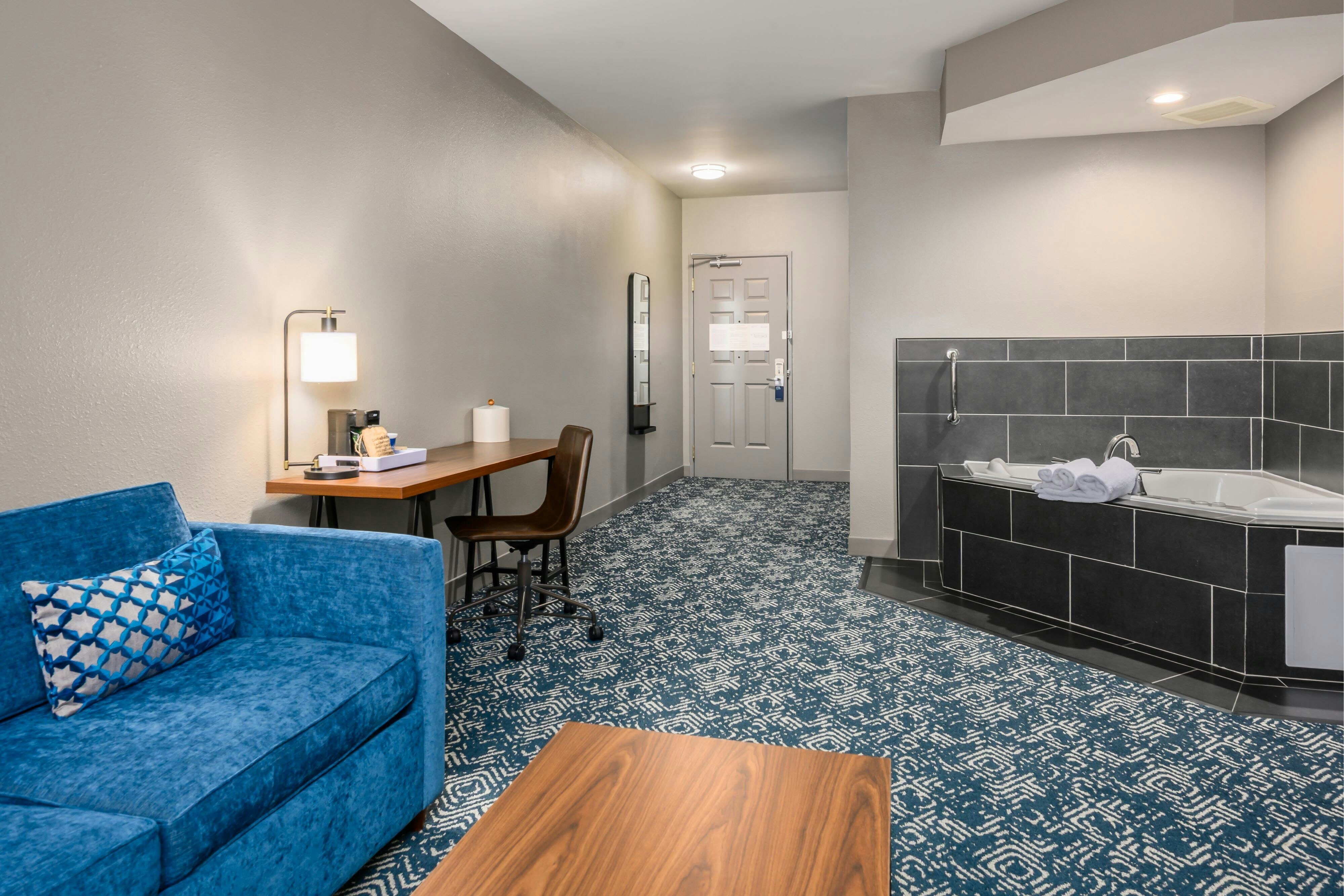 带梳化床和漩涡浴缸的特大床套房