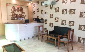 a hotel lobby with a reception desk , chairs , and a wall covered in monkey illustrations at Hotel Samrat