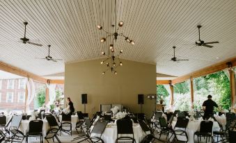 a large dining room with multiple tables and chairs arranged for a group of people at Bicentennial Inn
