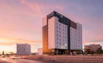 "a modern hotel building with the name "" courtyard by marriott "" on it , situated at an intersection near a highway" at Courtyard Ciudad Juarez