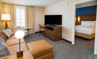 a hotel room with a comfortable bed , a flat - screen tv , a desk , and a couch at Residence Inn Upper Marlboro Joint Base Andrews