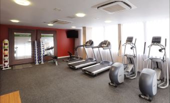 a well - equipped gym with various exercise equipment , including treadmills , elliptical machines , and weight machines at Hampton by Hilton Birmingham Broad Street