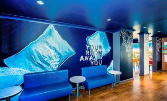 "a modern interior with blue walls and a large mural of the words "" your room away you "" on one wall" at Ibis Budget Brisbane Airport