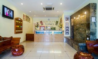 a clean and well - lit lobby with a reception desk , two potted plants , and a couch at Sun Inns Hotel Kuala Selangor