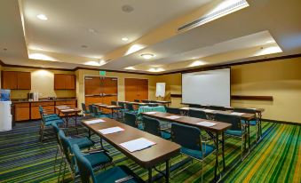 a conference room with tables and chairs arranged in rows , along with a whiteboard on the wall at Fairfield Inn & Suites Worcester Auburn