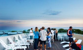 a group of people are gathered on a rooftop , enjoying the sunset and each other 's company at The Island Accommodation