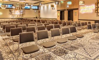 a large , empty conference room with rows of chairs arranged in a symmetrical fashion , ready for an event at Novotel Paris 14 Porte d'Orleans