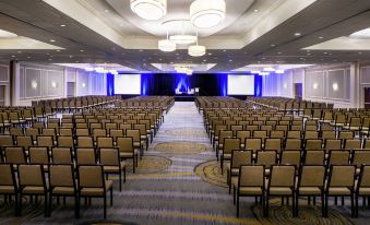 a large conference room with rows of chairs arranged in a semicircle , ready for a meeting or event at Hilton Albany