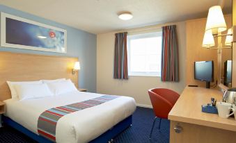 a hotel room with a large bed , desk , and chair , along with curtains and a tv at Travelodge Slough