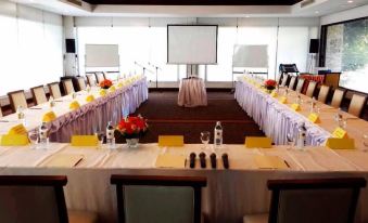 a conference room set up for a meeting , with chairs arranged in rows and a projector on the wall at Suwan Golf & Country Club