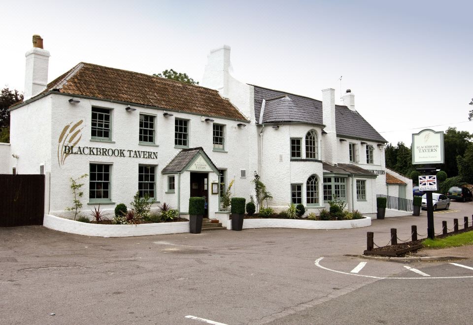 "a white building with a green roof and the name "" lockbrook tavern "" written in black letters" at Taunton Ruishton (M5, J25)