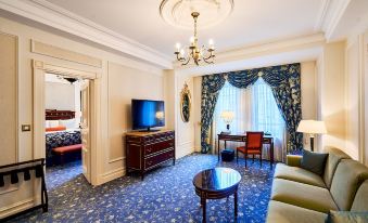 a luxurious hotel room with a large bed , a flat - screen tv , and a comfortable living area at Fairmont Grand Hotel - Kyiv
