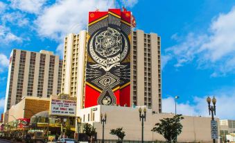 a tall building with a large red and white mural on its side , creating a unique and eye - catching display at Plaza Hotel & Casino