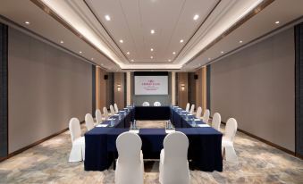 a large room is arranged for an event, with long tables and chairs positioned facing the front at Crowne Plaza Shanghai Nanjing Road