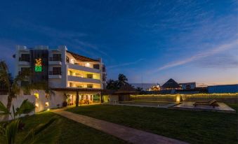 a large building with multiple levels , surrounded by a grassy area and a body of water at Hotel Rio Lagartos