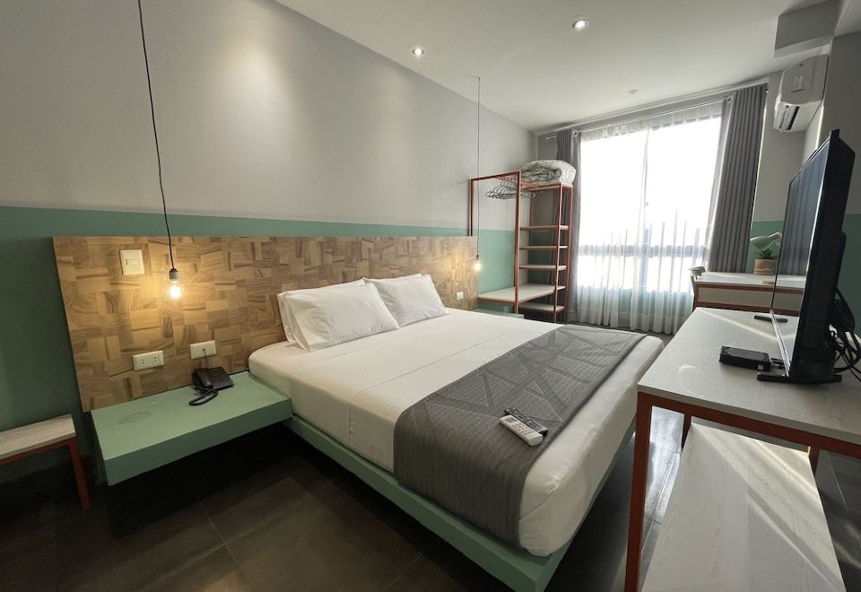a modern hotel room with two beds , one of which is made up and has white bedding , under wooden panels at Hotel G