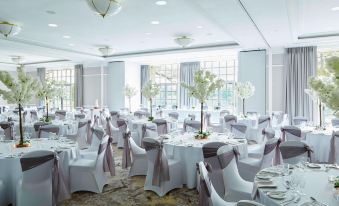 a large banquet hall with tables covered in white tablecloths and chairs arranged for a formal event at Forest of Arden Country Club