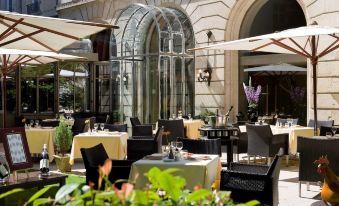 an outdoor dining area at a restaurant , with tables and chairs set up for guests to enjoy their meal at Grand Hotel la Cloche Dijon - MGallery