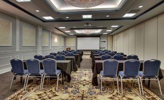 a large conference room with rows of chairs arranged in a semicircle , and a projector mounted on the wall at The Inn at Wise