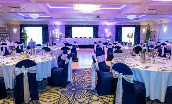 a large banquet hall with several tables set up for a formal event , possibly a wedding reception at Arklow Bay Hotel
