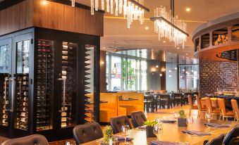 a dining room with a long wooden table and chairs , as well as a wine cellar filled with bottles at The Charter Hotel Seattle, Curio Collection by Hilton