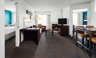 a hotel room with a living area , dining table , and fireplace , along with comfortable furniture and amenities at Residence Inn Provo North
