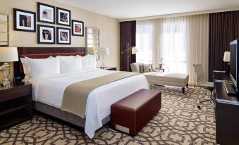 a large bed with a white and brown comforter is in the middle of a room at Delta Hotels by Marriott Baltimore Hunt Valley