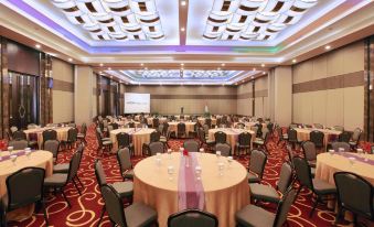 a large banquet hall filled with round tables and chairs , ready for a formal event at ASTON Imperial Bekasi Hotel & Conference Center