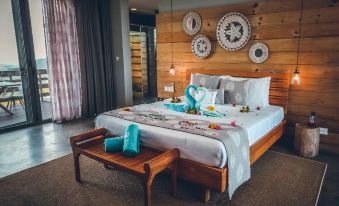 a large bed with a wooden headboard and footboard is in a room with a bench at Chalets Chamarel