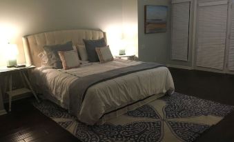 a cozy bedroom with a large bed , hardwood floors , and a rug on the floor at The Waterford