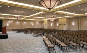 a large , empty conference room with rows of chairs and a chandelier hanging from the ceiling at Hilton Melbourne, FL