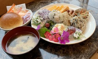 a dining table with a bowl of soup , a plate of food , and a cup of milk at Toyoko Inn Oita Ekimae