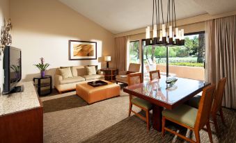 a living room and dining area with a couch , dining table , chairs , and large windows at The Westin Rancho Mirage Golf Resort & Spa