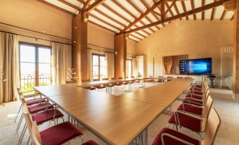 a large conference room with a long table and chairs arranged in a semicircle , providing seating for a large group of people at Hotel Creu de Tau Art&Spa-Adults Only