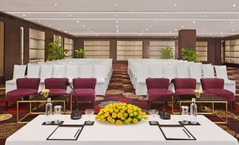 a conference room set up for a meeting , with rows of chairs arranged in a semicircle around a table at Radisson Hotel Agra