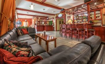 a cozy bar with a bar counter , multiple couches , and chairs , creating an inviting atmosphere for socializing at Hotel Golfer